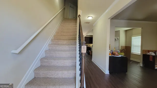 a hallway with wooden floor and stairs