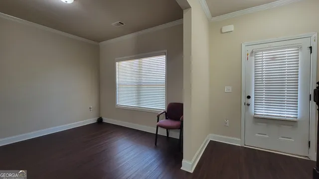 a view of a room with wooden floor and a window