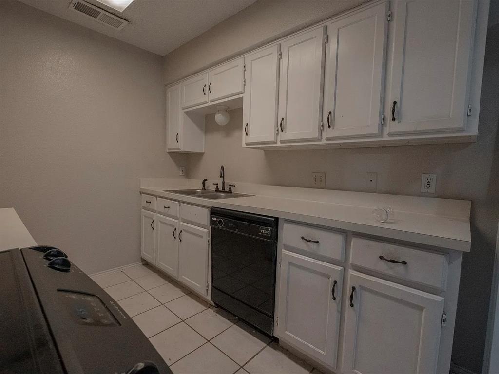 675 Harbor Drive North, Unit D Azle, TX 76020 - Photo 3 of 8 Kitchen with white cabinets, dishwasher, light tile patterned flooring, and light countertops