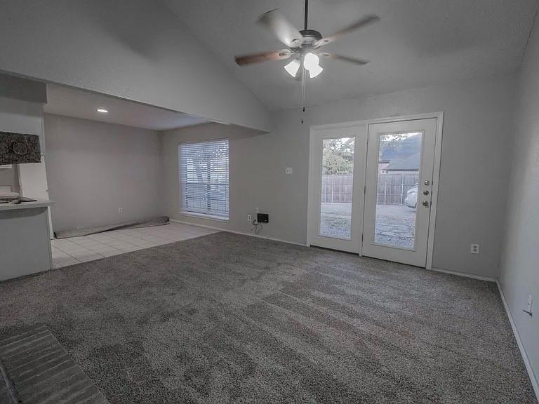 675 Harbor Drive North, Unit D Azle, TX 76020 - Photo 6 of 8 Unfurnished living room with light carpet, a ceiling fan, healthy amount of natural light, and high vaulted ceiling