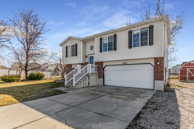 4239 West 5325th Street South Roy, UT 84067 - Photo 2 of 26 Raised ranch with brick siding, driveway, and a garage