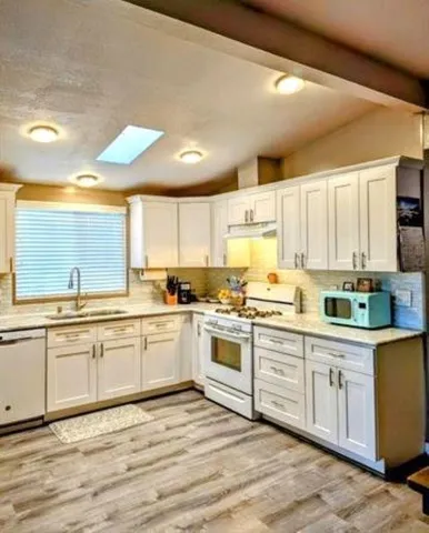 a large kitchen with cabinets and wooden floor