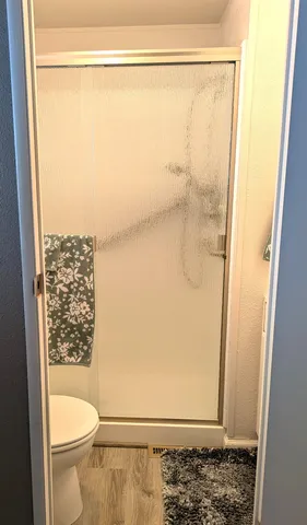 a bathroom with a granite countertop shower and a toilet