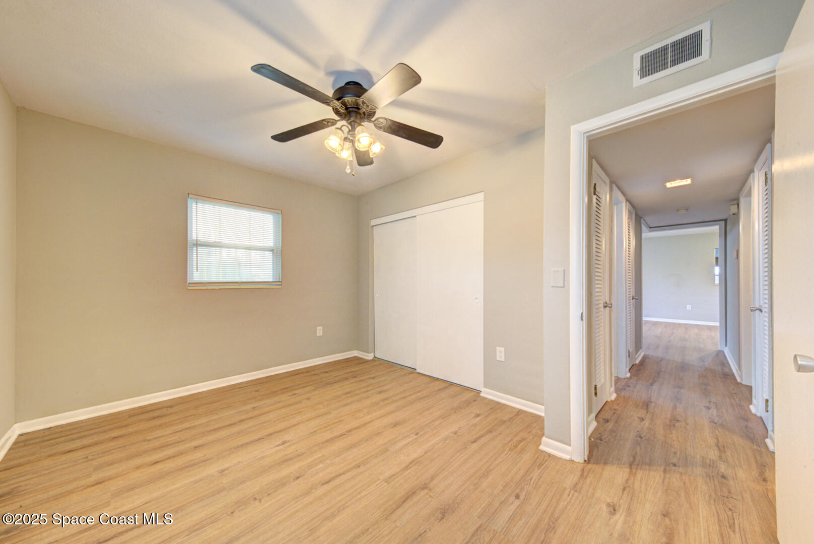 813 7th Street Merritt Island, FL 32953 - Photo 12 of 28 an empty room with wooden floor fan and windows