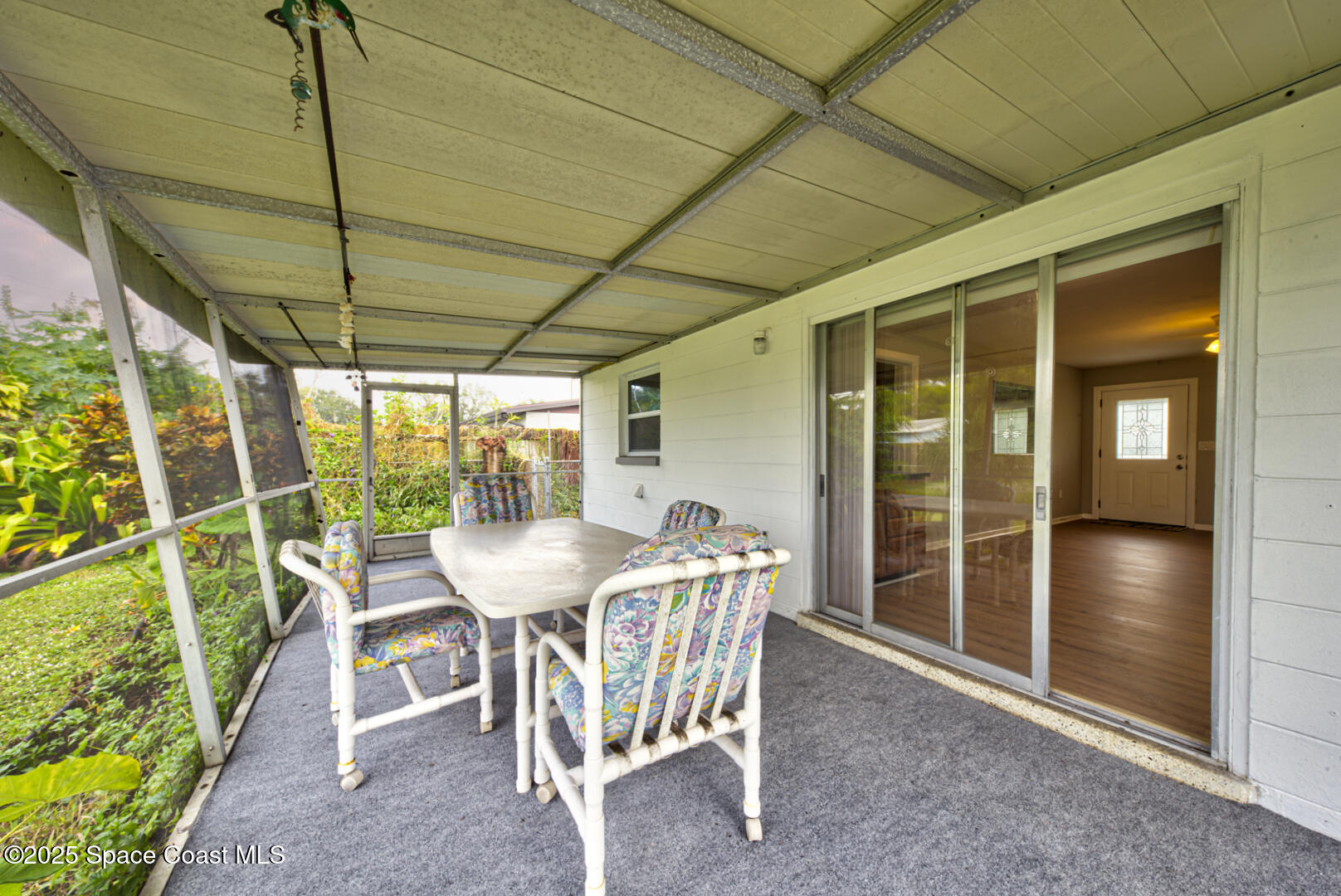813 7th Street Merritt Island, FL 32953 - Photo 20 of 28 a patio with table and chairs and potted plants