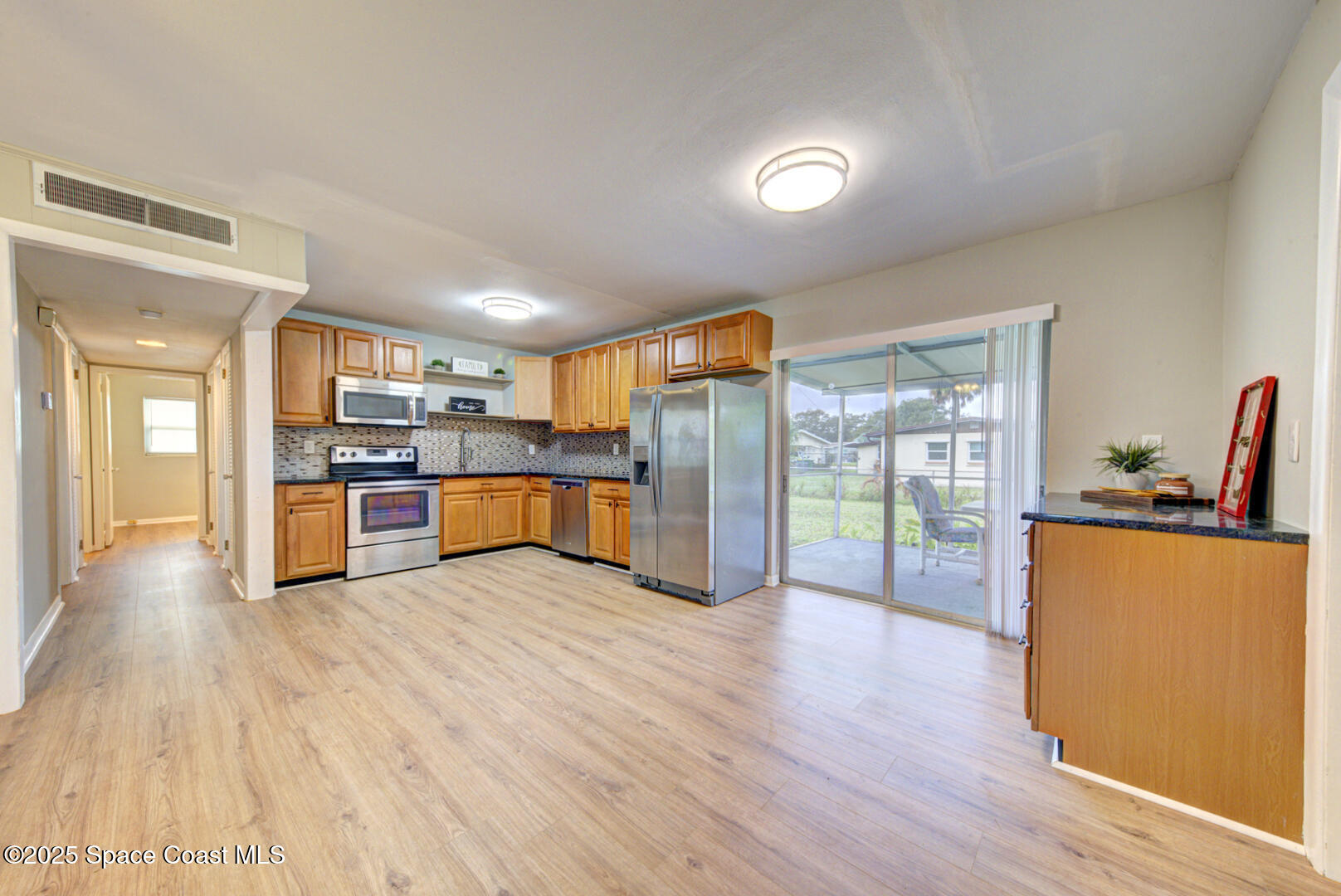 813 7th Street Merritt Island, FL 32953 - Photo 2 of 28 a large kitchen with stainless steel appliances granite countertop a refrigerator and a stove top oven