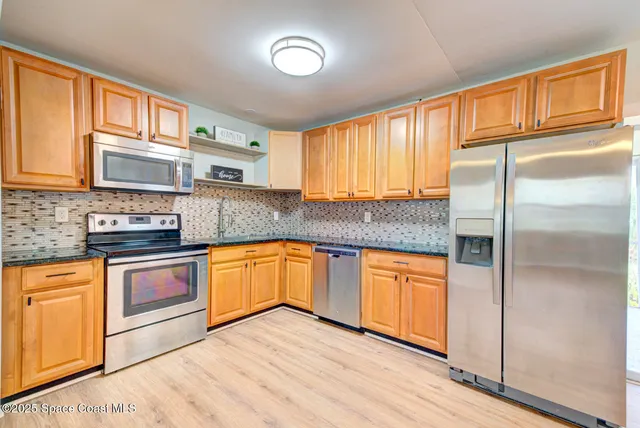 a kitchen with stainless steel appliances granite countertop a refrigerator sink and cabinets