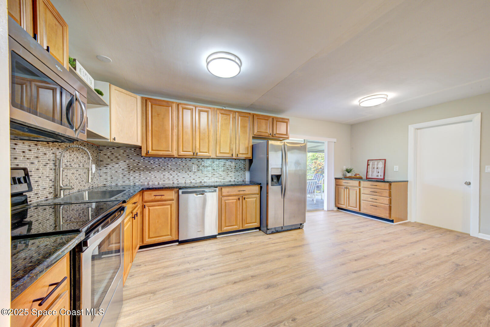 813 7th Street Merritt Island, FL 32953 - Photo 4 of 28 a kitchen with stainless steel appliances granite countertop a refrigerator a sink a stove and a wooden floors