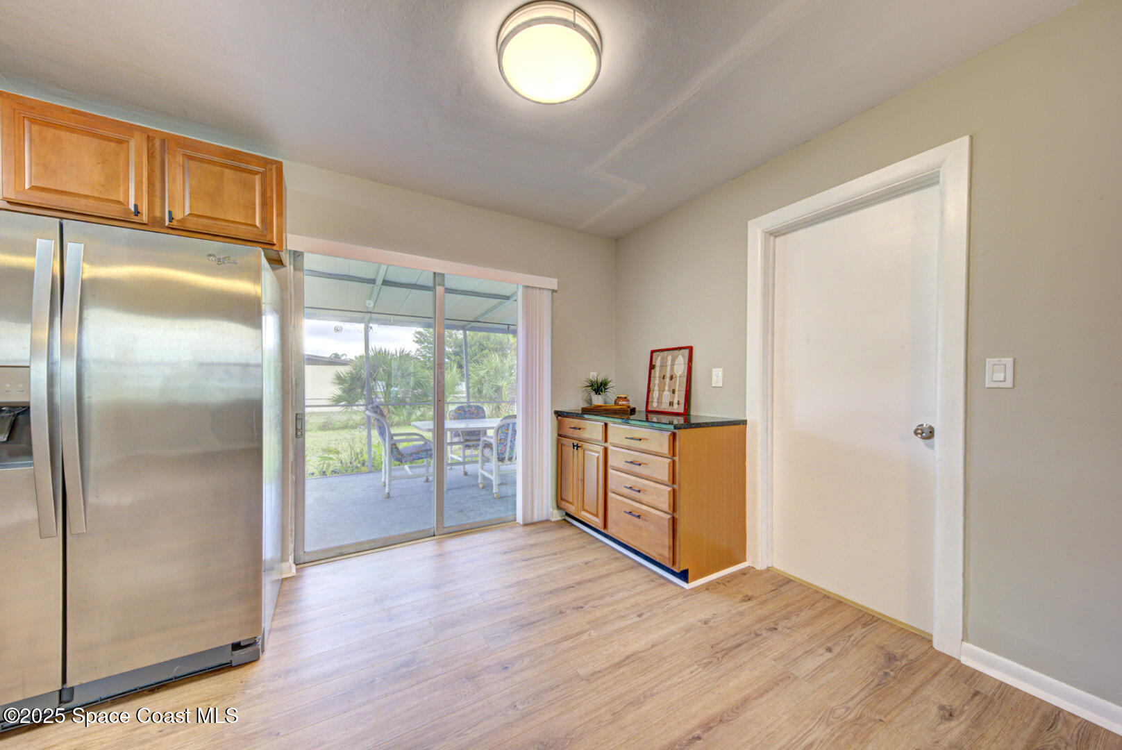 813 7th Street Merritt Island, FL 32953 - Photo 6 of 28 a view of a kitchen with a fridge and wooden floor