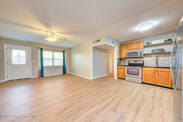 a view of kitchen with wooden floor electronic appliances and window