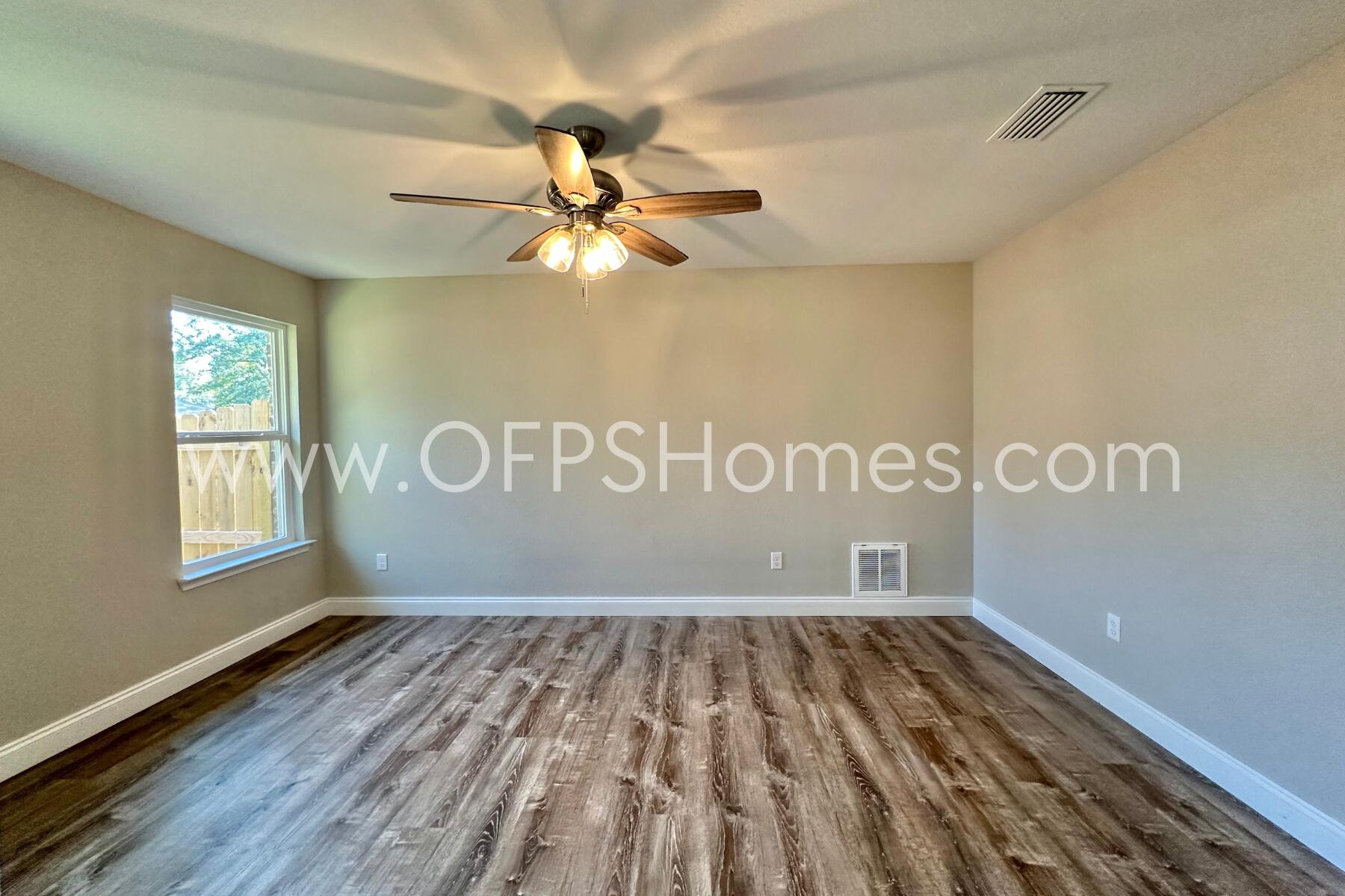 6762 Trailride North Milton, FL 32570 - Photo 12 of 25 a view of an empty room with wooden floor and a window