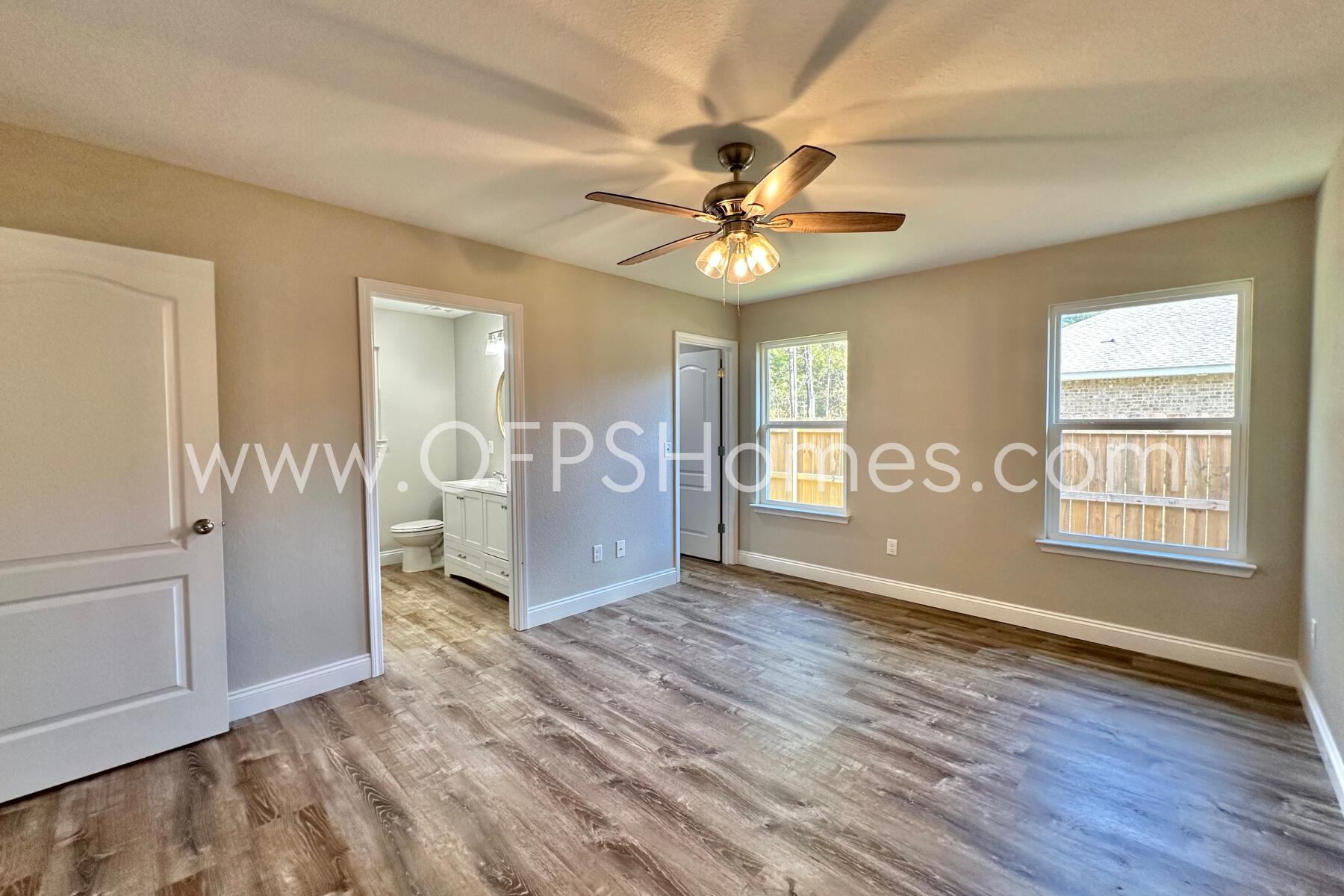 6762 Trailride North Milton, FL 32570 - Photo 10 of 25 an empty room with wooden floor fan and windows
