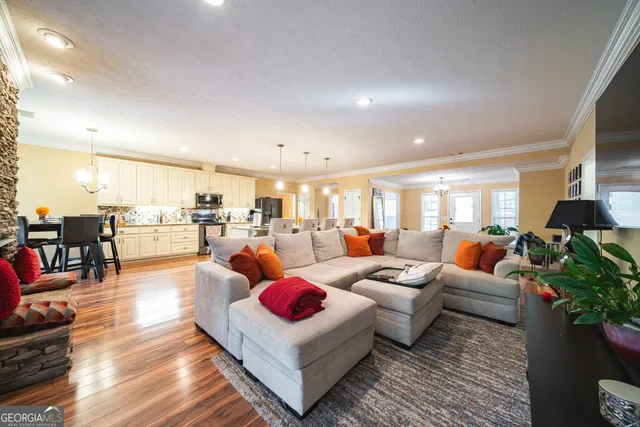 a living room with lots of furniture and view of kitchen