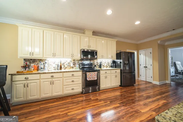 a kitchen with granite countertop stainless steel appliances a refrigerator sink and microwave