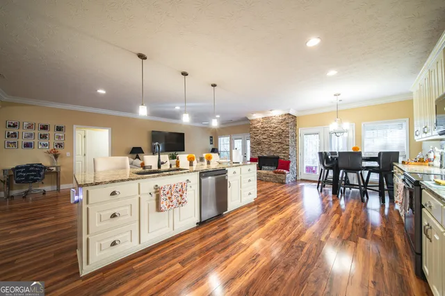 a kitchen with stainless steel appliances granite countertop a large center island and a wooden floors