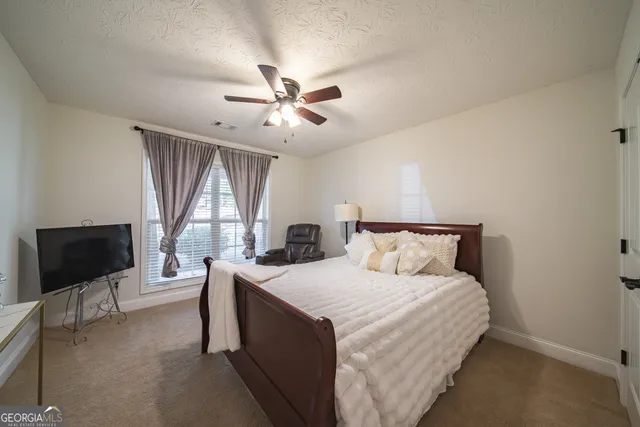 a bed room with a bed window and a flat screen tv