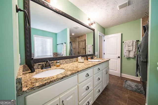 a bathroom with a granite countertop sink and a mirror