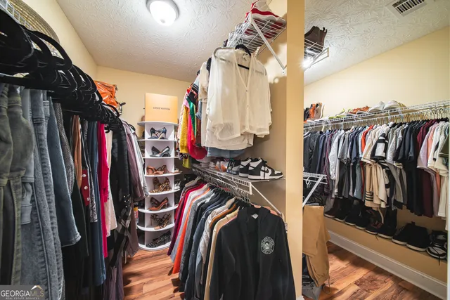 a view of walk in closet with clothes and shoes