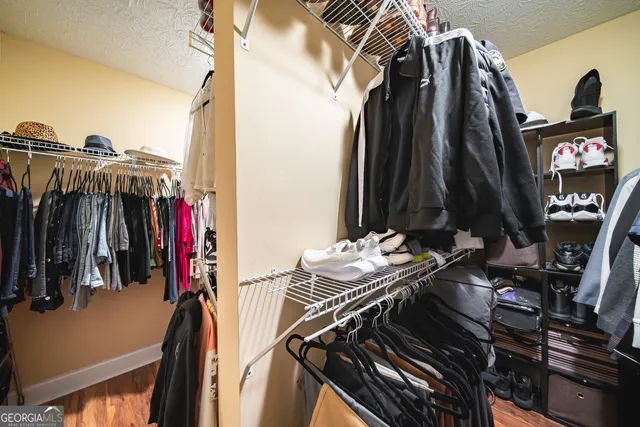 a view of walk in closet with clothes and shoes