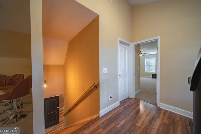 a view of a hallway with wooden floor and entryway