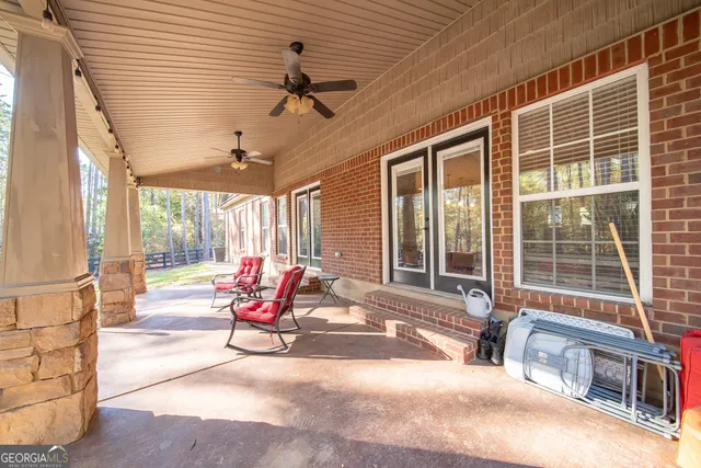 a view of a patio with a table and chairs and floor to ceiling window
