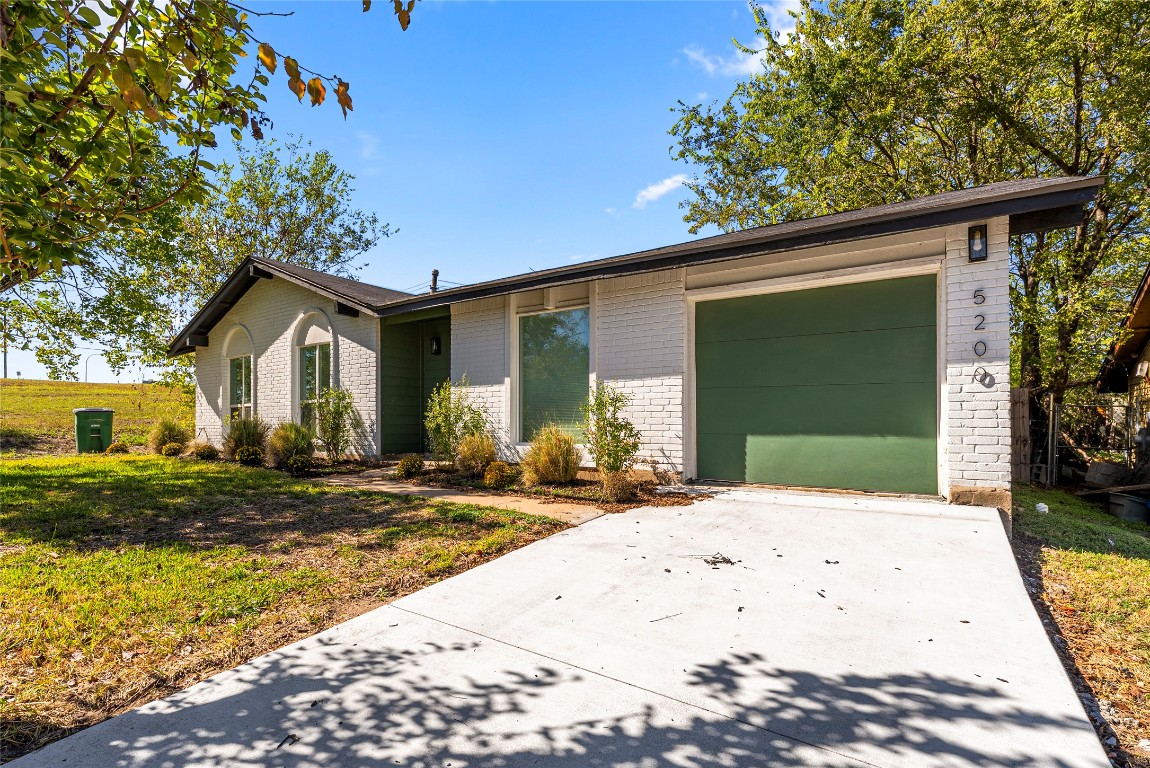 5200 King Charles Drive Austin, TX 78724 - Photo 3 of 22 Mid-century inspired home with brick siding, concrete driveway, a garage, and a front yard