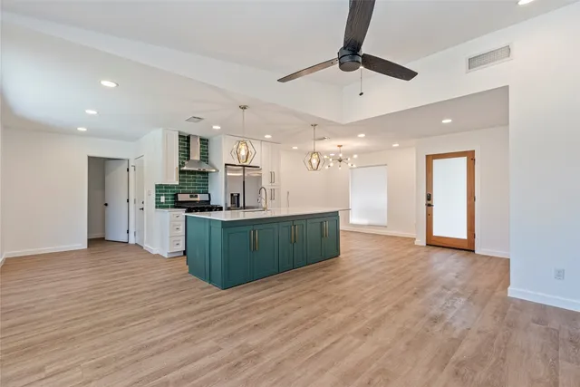 a kitchen with stainless steel appliances kitchen island a refrigerator sink and cabinets
