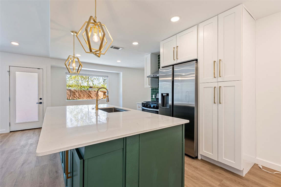 5200 King Charles Drive Austin, TX 78724 - Photo 8 of 22 Kitchen with white cabinets, stainless steel appliances, light stone countertops, recessed lighting, and green cabinets