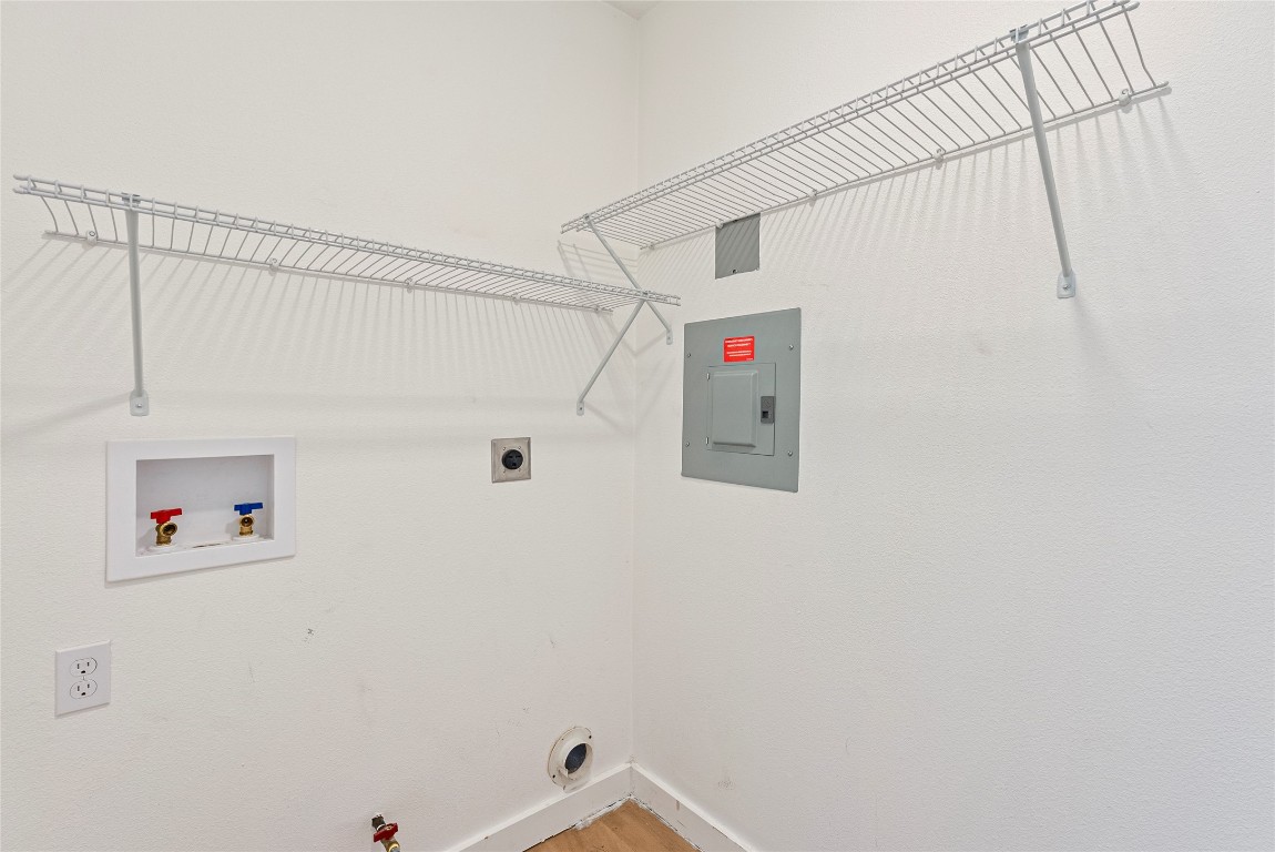 5200 King Charles Drive Austin, TX 78724 - Photo 10 of 22 Washroom featuring electric panel, hookup for a washing machine, electric dryer hookup, wood finished floors, and hookup for a gas dryer