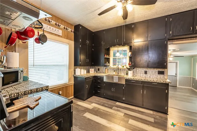 a kitchen with stainless steel appliances kitchen island granite countertop a sink and cabinets