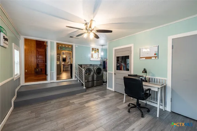 a view of a workspace with wooden floor and windows