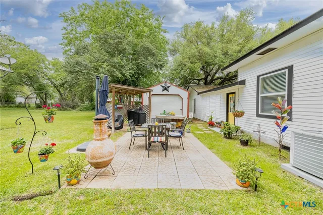 a view of a patio with a table chairs and a backyard