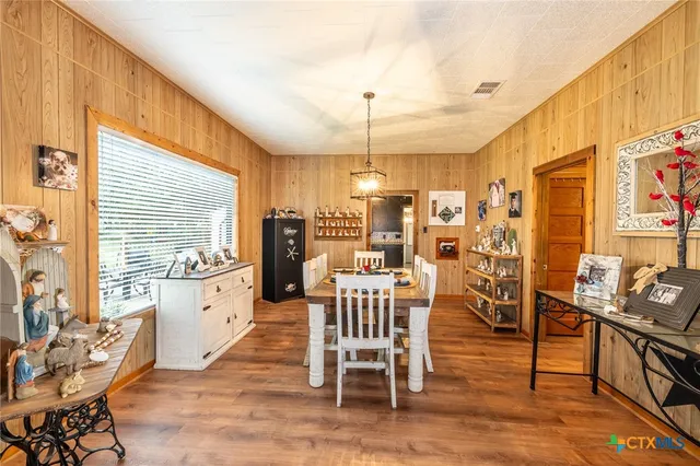 a kitchen with granite countertop a dining table chairs stainless steel appliances and cabinets