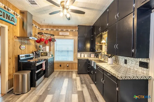 a kitchen with granite countertop stainless steel appliances and wooden cabinets