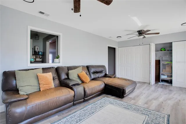 a living room with furniture and a ceiling fan