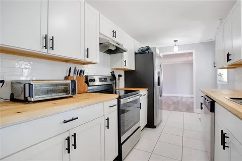 a kitchen with stainless steel appliances granite countertop a refrigerator and a stove