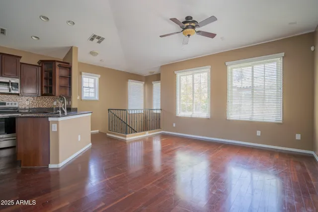 a view of an empty room with window and wooden floor