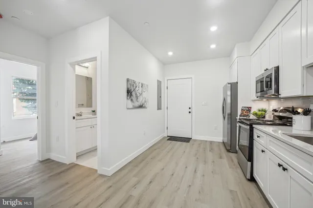 a view of a kitchen with wooden floor and electronic appliances