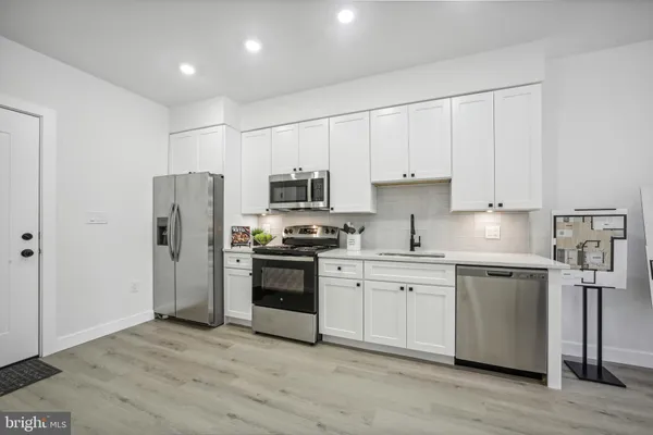 a kitchen with stainless steel appliances granite countertop a refrigerator a stove top oven a sink and dishwasher
