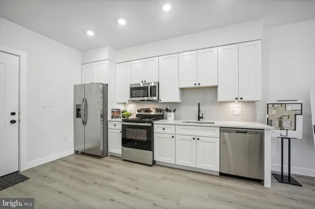 a kitchen with stainless steel appliances granite countertop a refrigerator a stove top oven a sink and dishwasher