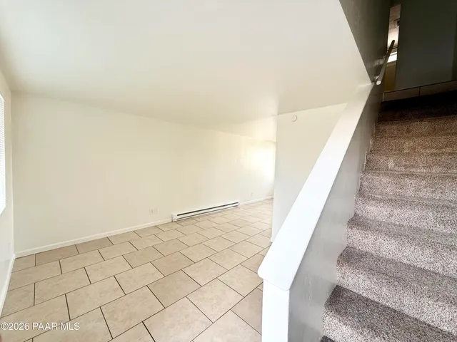 a view of staircase with white walls and white door