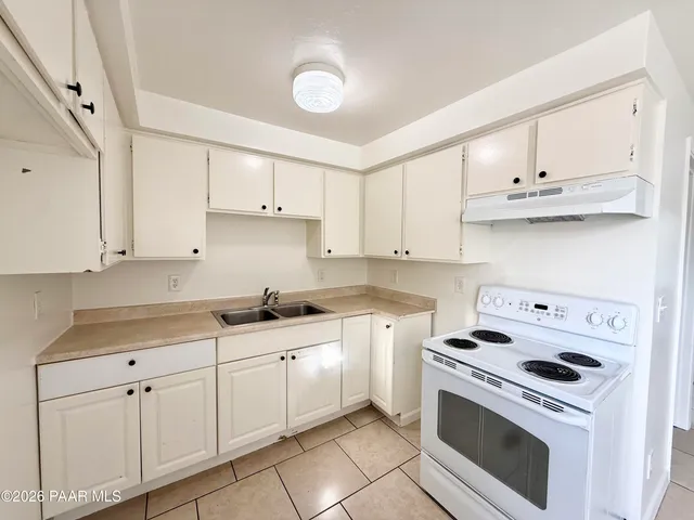 a kitchen with granite countertop white cabinets and white appliances