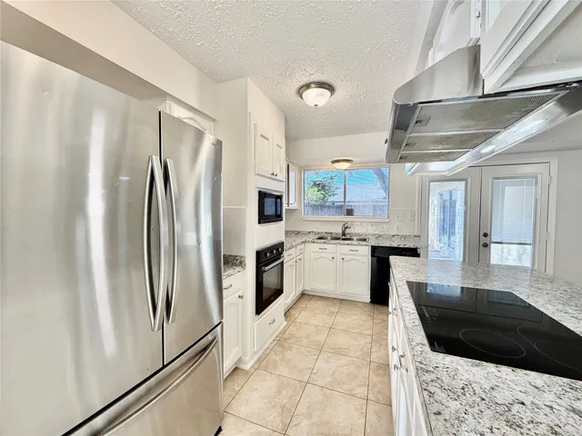 a kitchen with a refrigerator a sink and cabinets