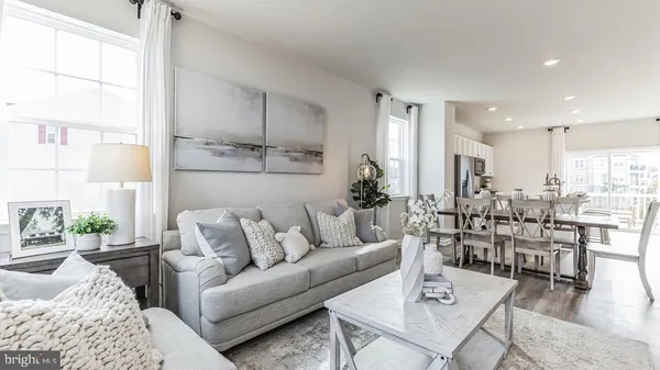 a living room with lots of furniture and view of kitchen