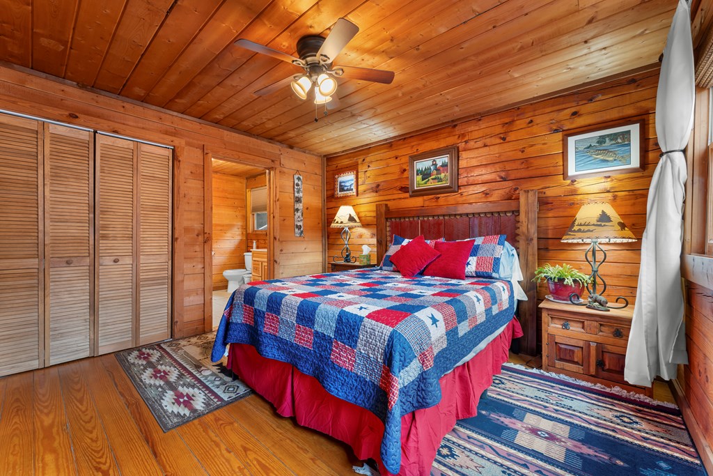 451 Summit Road Otto, NC 28763 - Photo 19 of 40 a bedroom with a bed and wooden floor