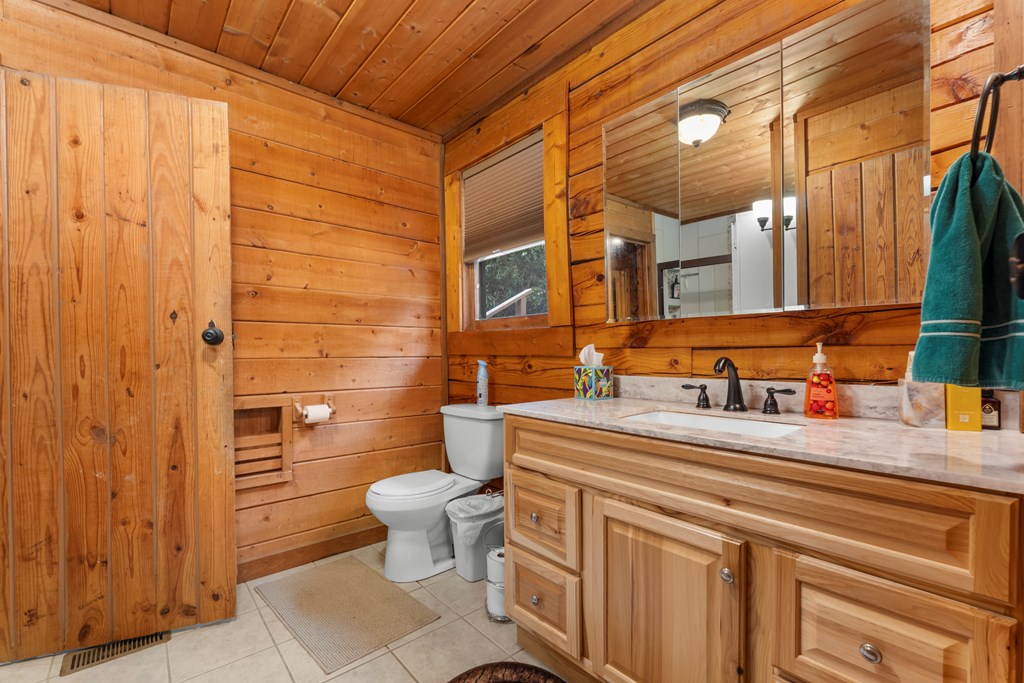 451 Summit Road Otto, NC 28763 - Photo 36 of 40 a bathroom with a sink a toilet and a mirror
