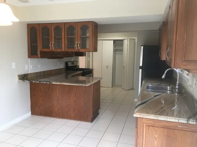 a kitchen with granite countertop a sink a stove and a microwave oven