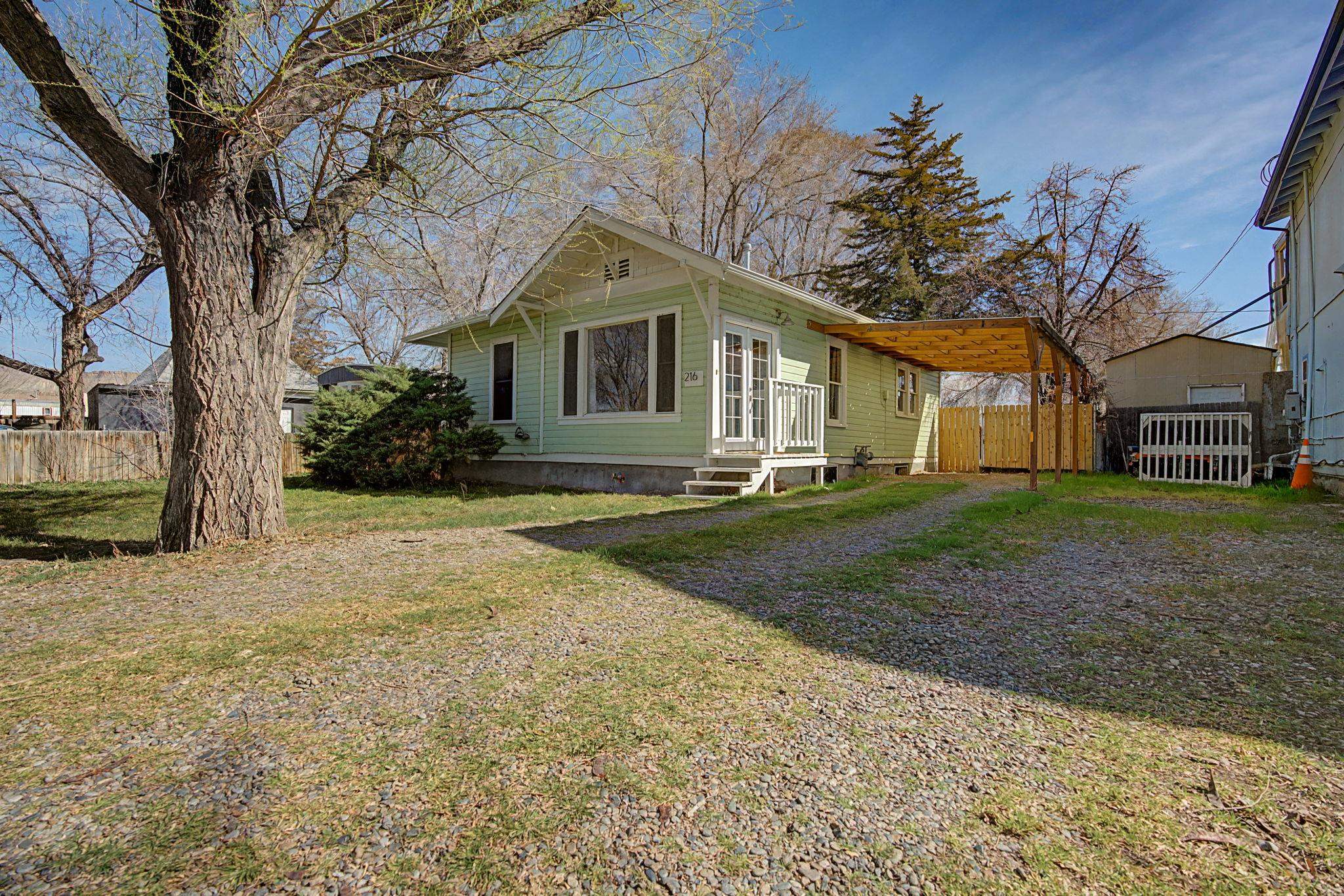 a front view of a house with a yard and trees