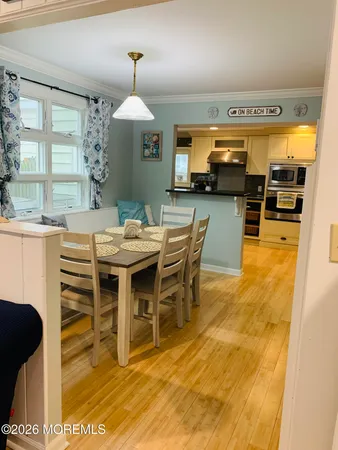 a dining room with furniture a chandelier and wooden floor
