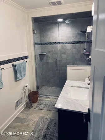a bathroom with a sink a toilet and shower
